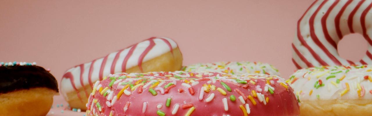 A selection of different colored, iced donuts with sprinkles